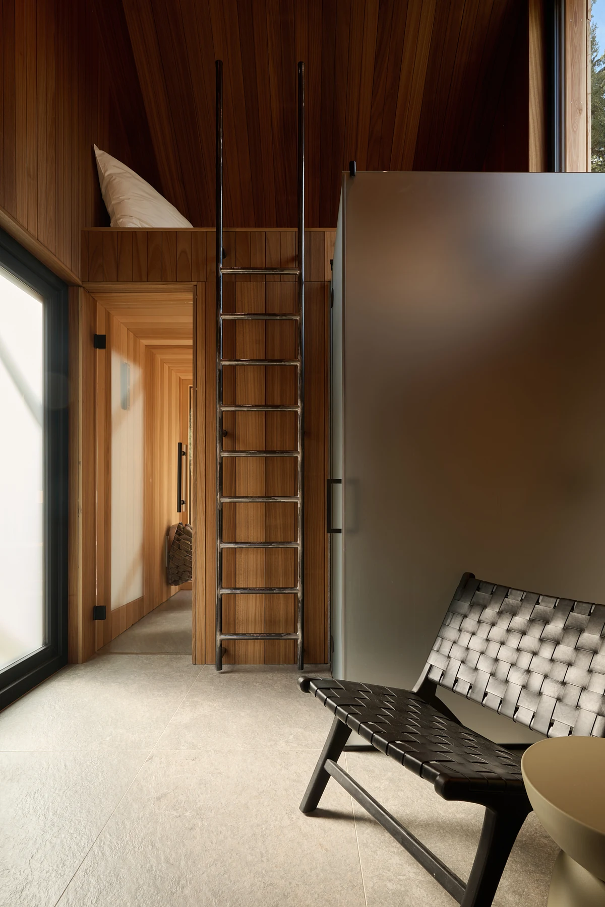 A woven armchair and the ladder to the built-in sleeping loft