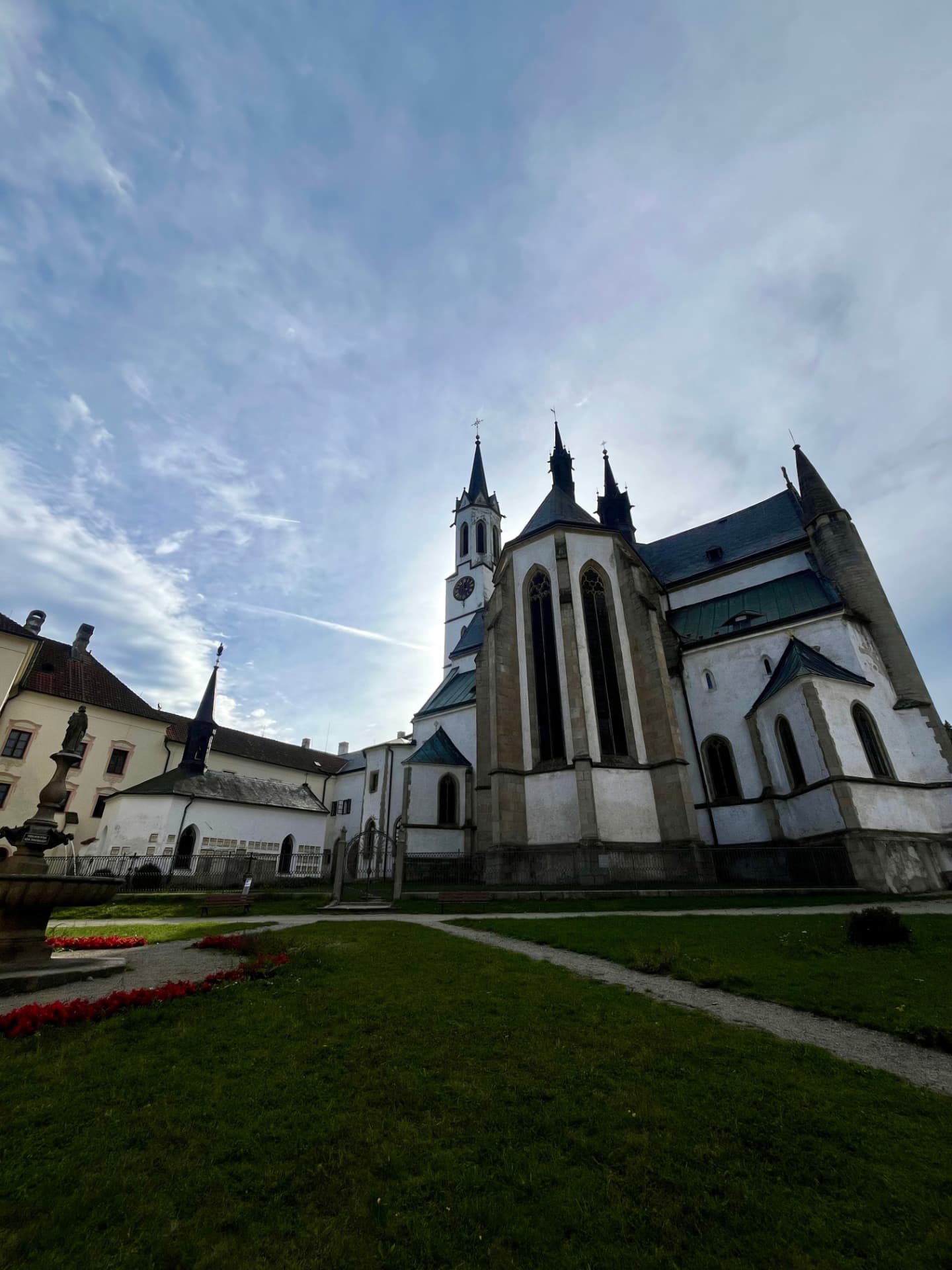 The monastery church and buildings of Vyšší Brod seen across the courtyard lawn